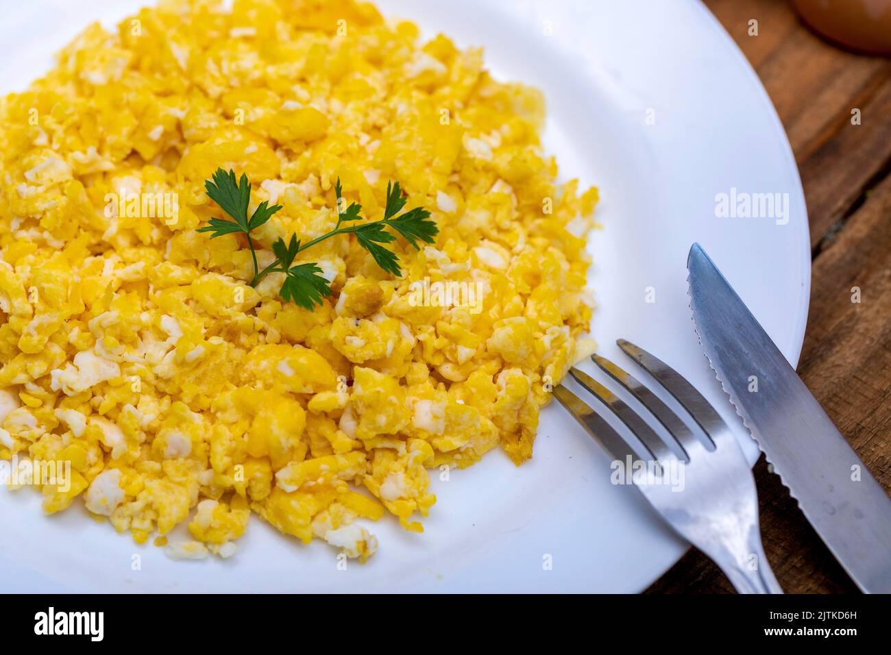 fresh scrambled eggs on white plate on breakfast table Stock Photo - Alamy