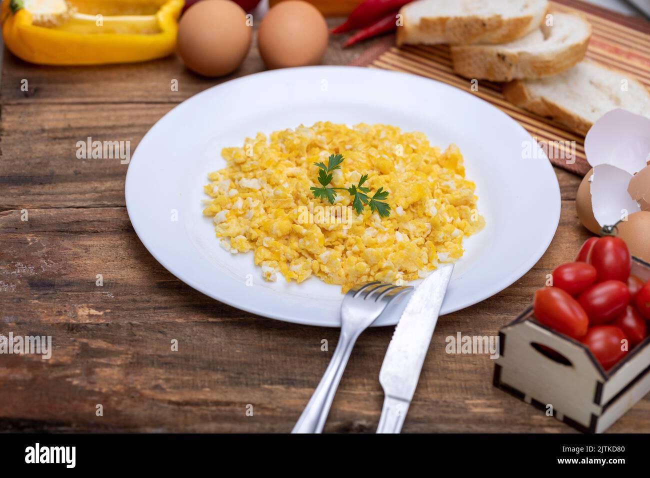 fresh scrambled eggs on white plate on breakfast table Stock Photo - Alamy