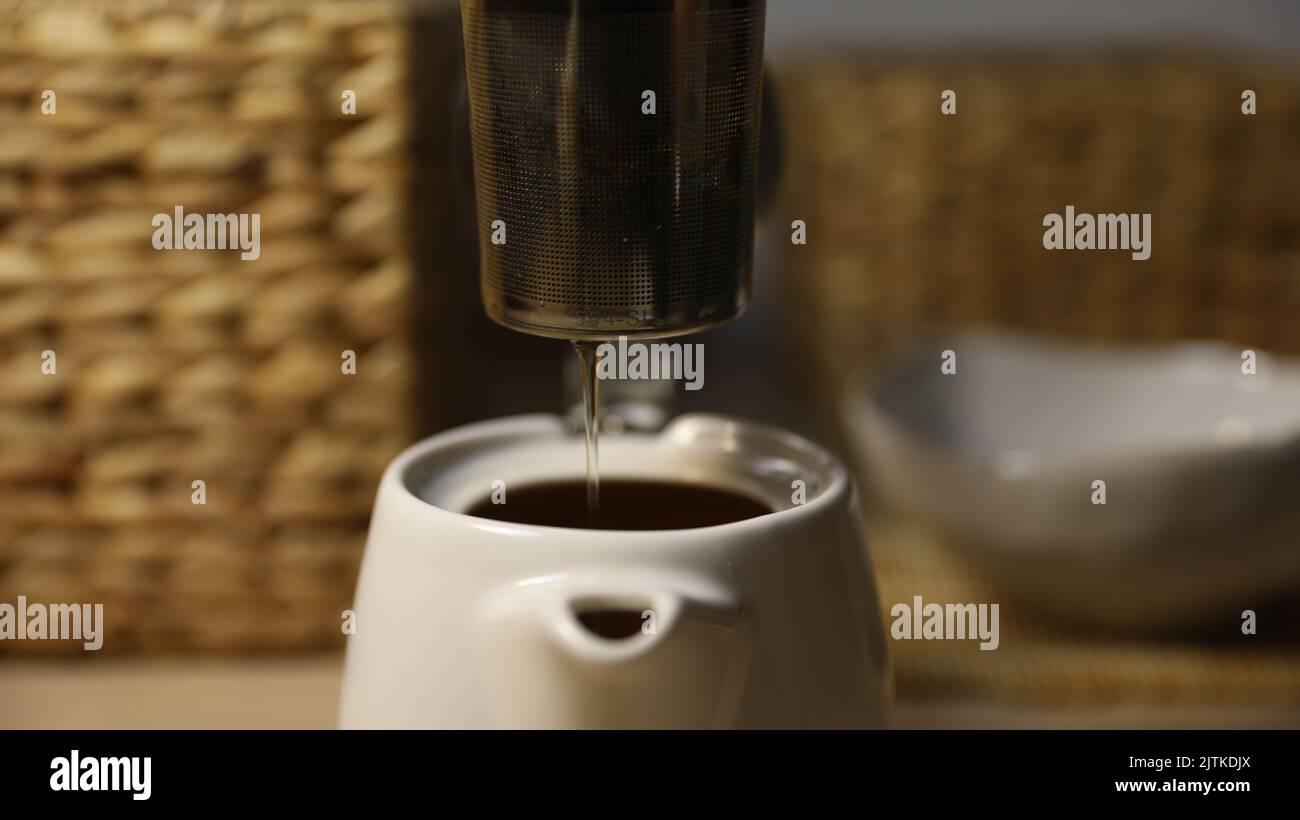 Basket being lifted out of tea pot Stock Photo - Alamy