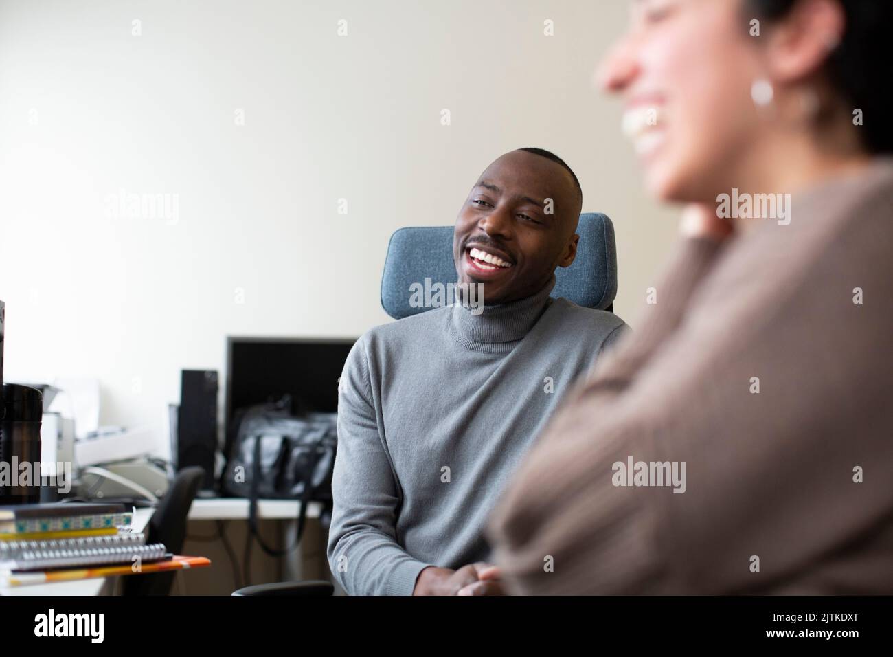 Happy multiracial business colleagues sitting in office Stock Photo - Alamy