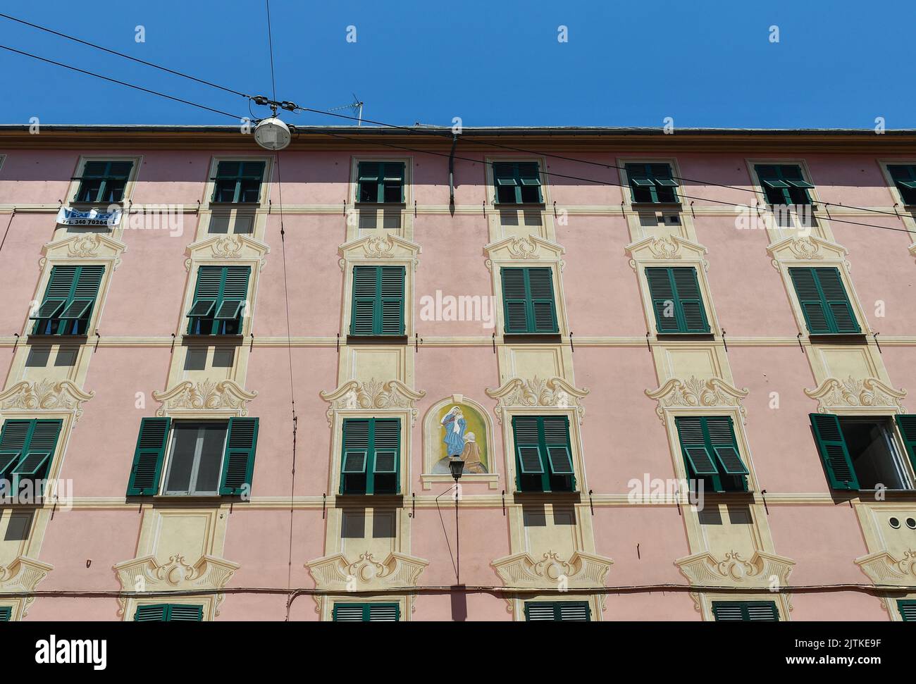 Façade of an old palace with a painted shrine of Our Lady of Montallegro and trompe l'oeil decorations, Nervi, Genoa, Liguria, Italy Stock Photo