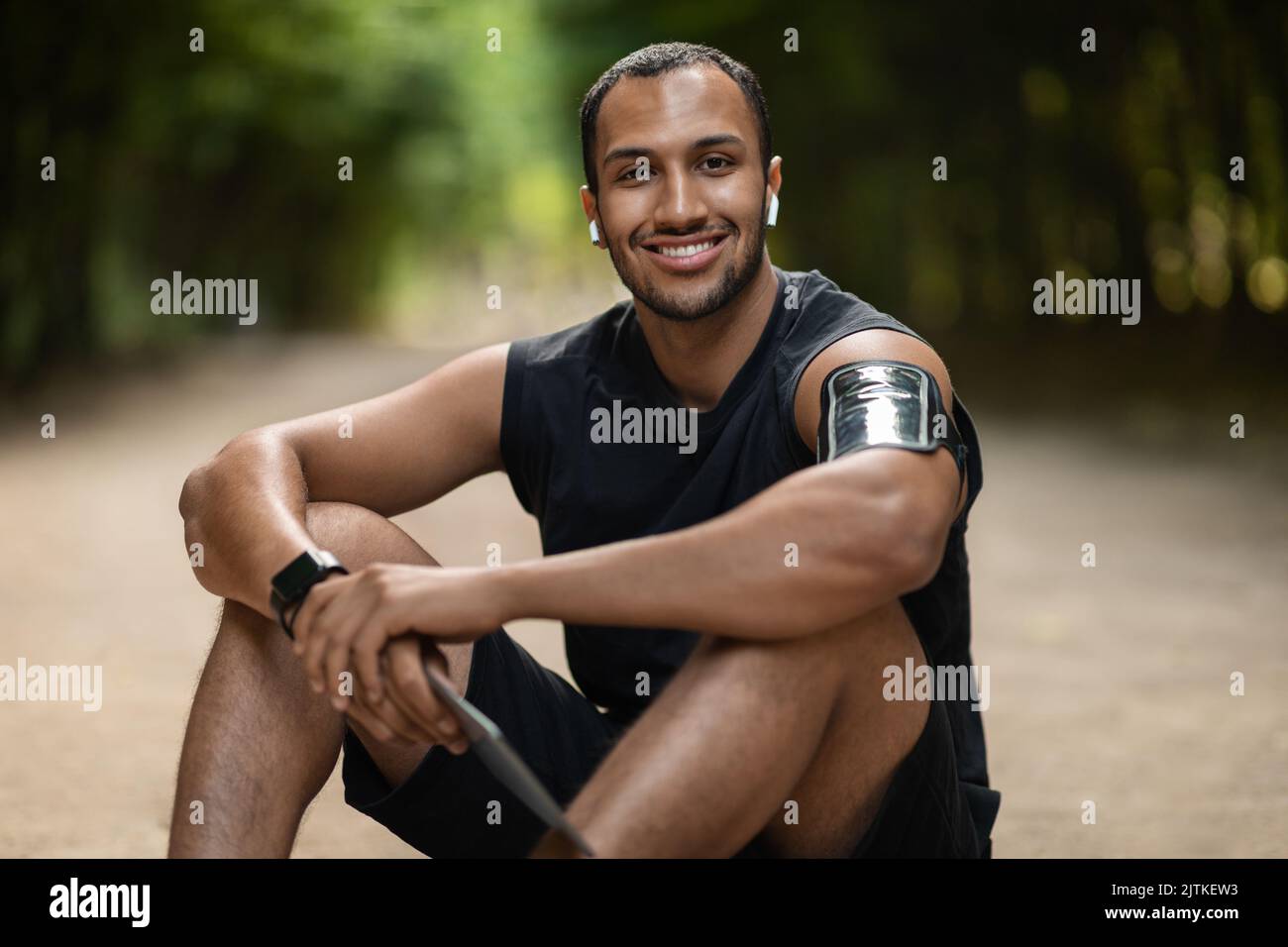 Cheerful black guy sportsman having break, using digital tablet Stock Photo