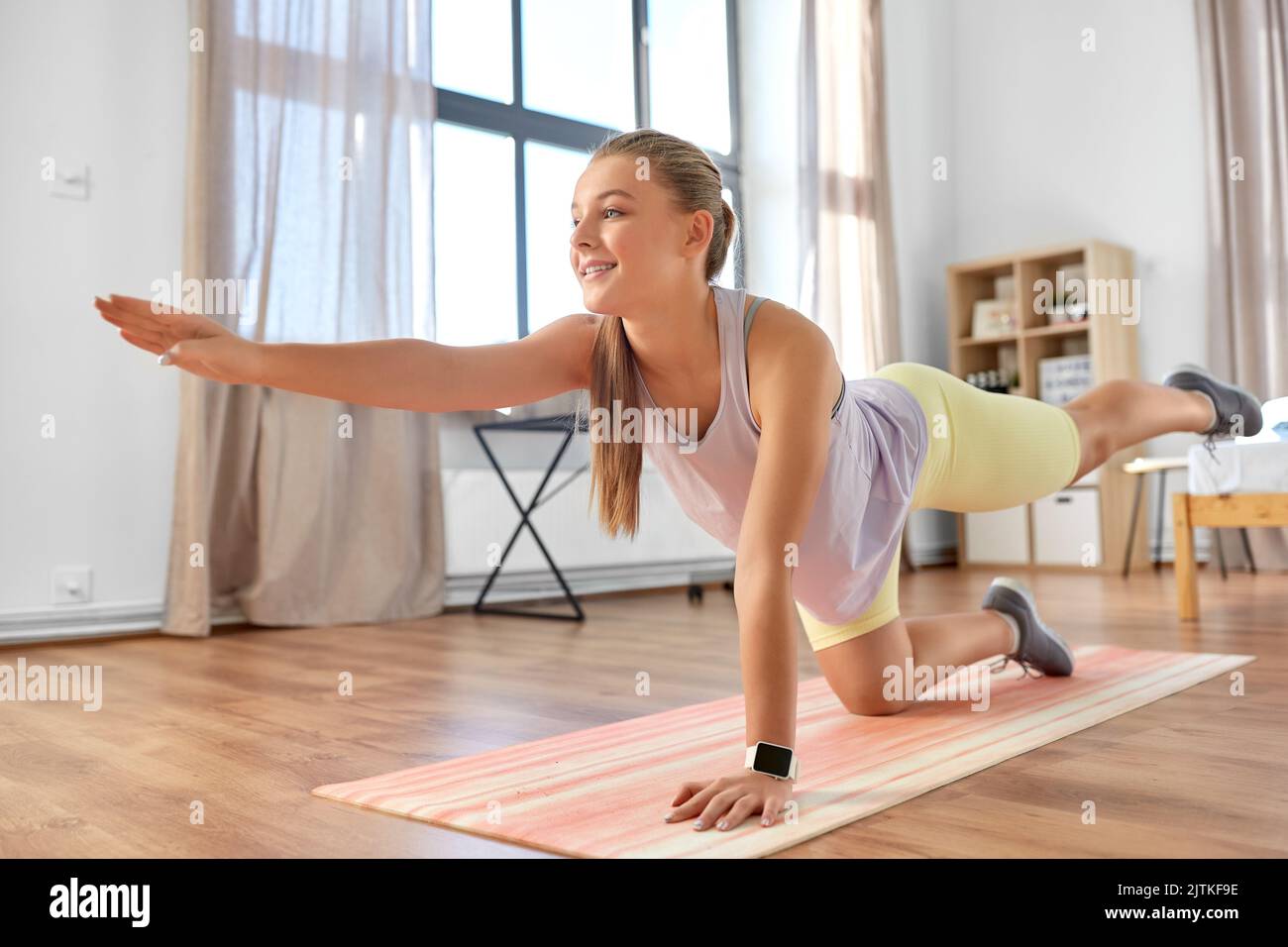 happy teenage girl exercising on yoga mat at home Stock Photo - Alamy