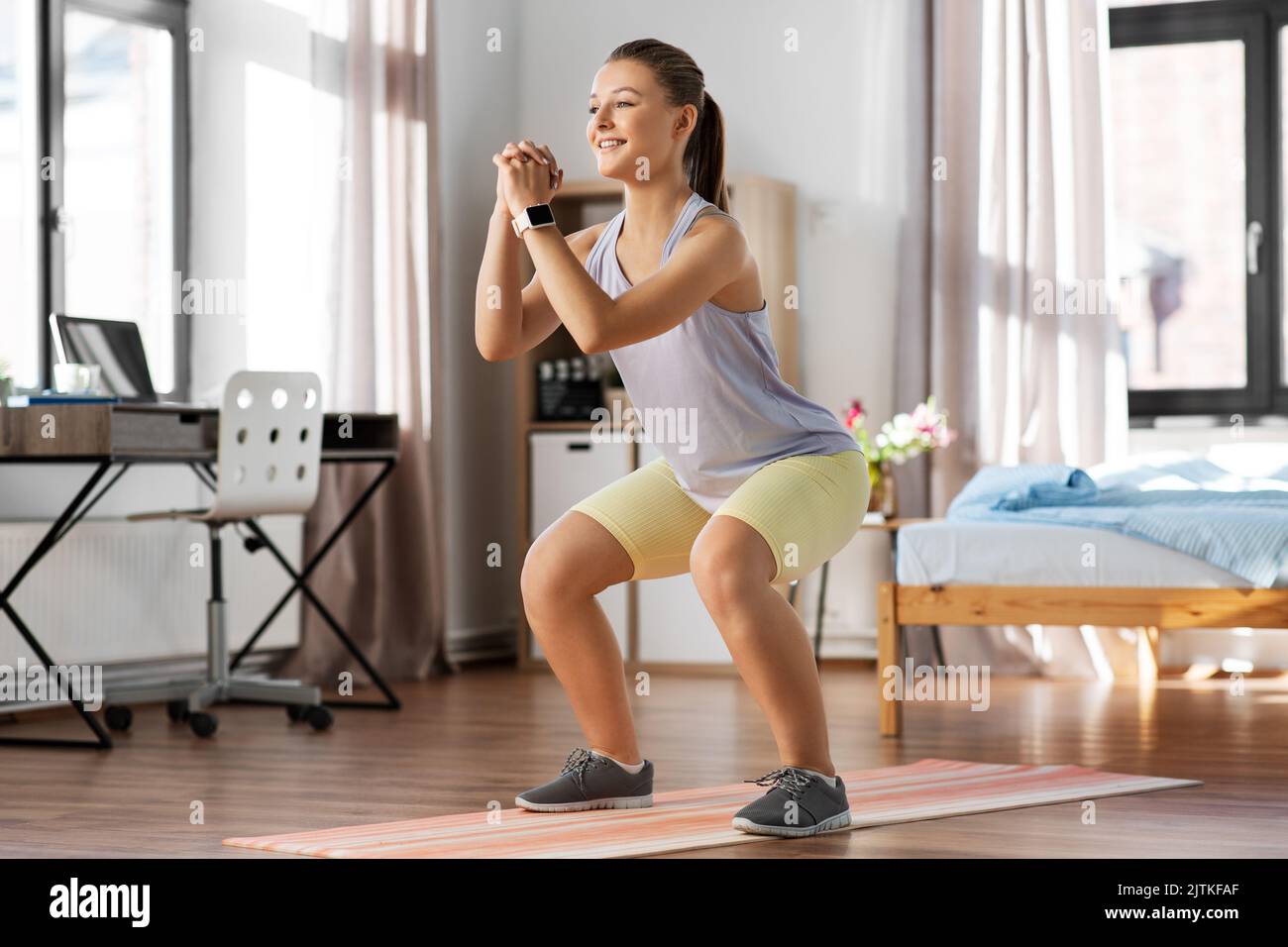 happy teenage girl exercising on yoga mat at home Stock Photo - Alamy