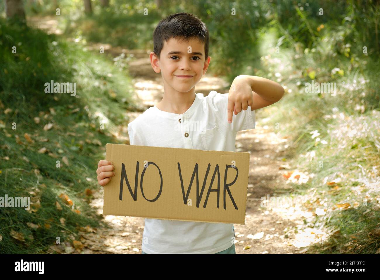 child holds a sign in his hands with the message 'no war' Stock Photo