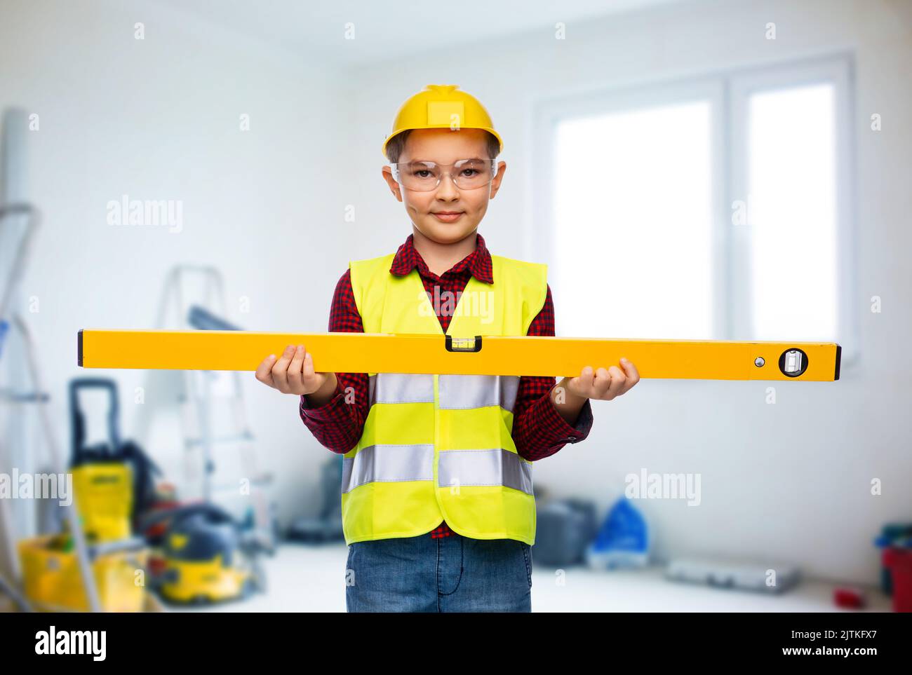 boy in construction helmet and vest with level Stock Photo Alamy