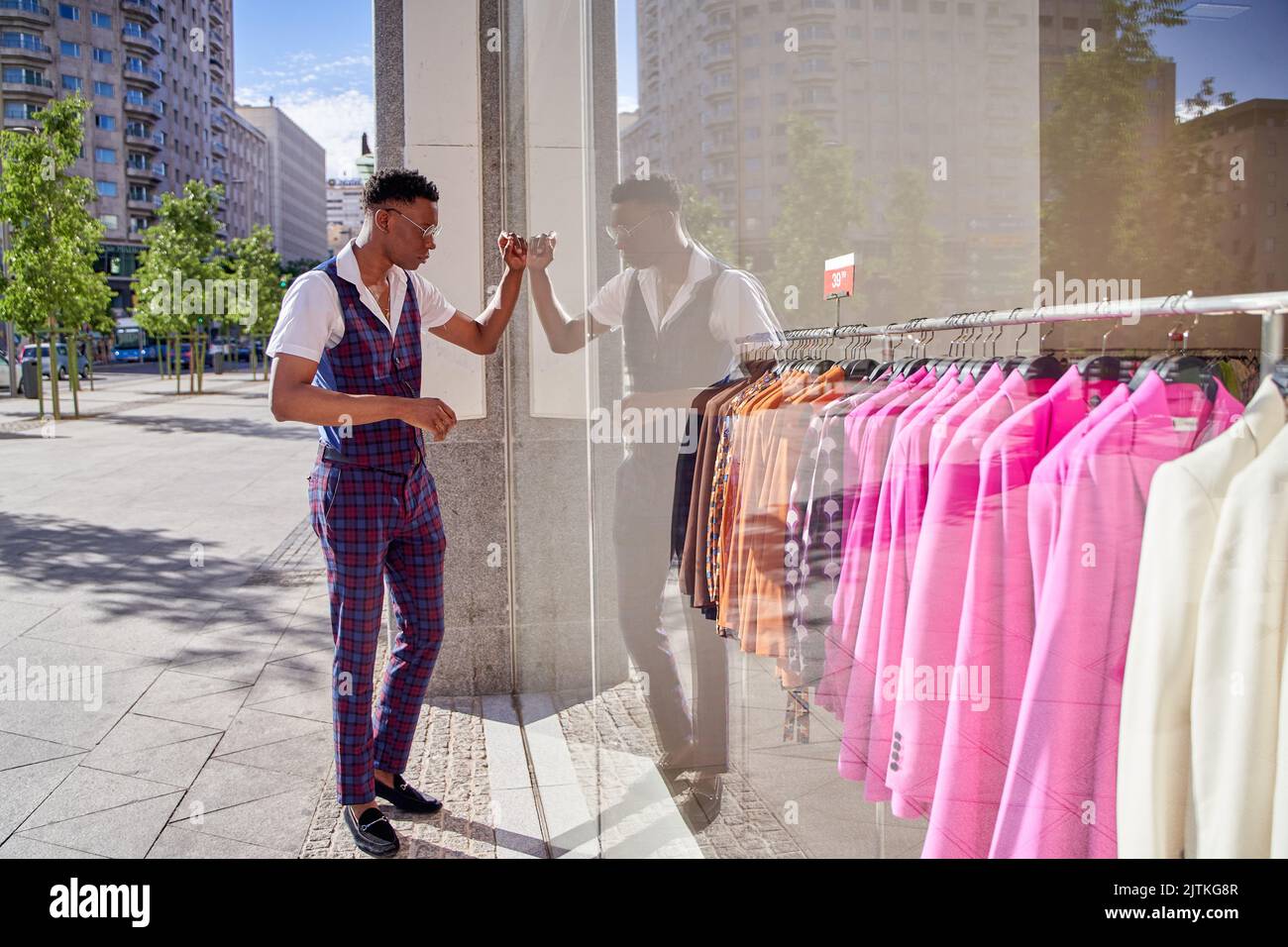 man looking in a clothes shop window. shopping time Stock Photo
