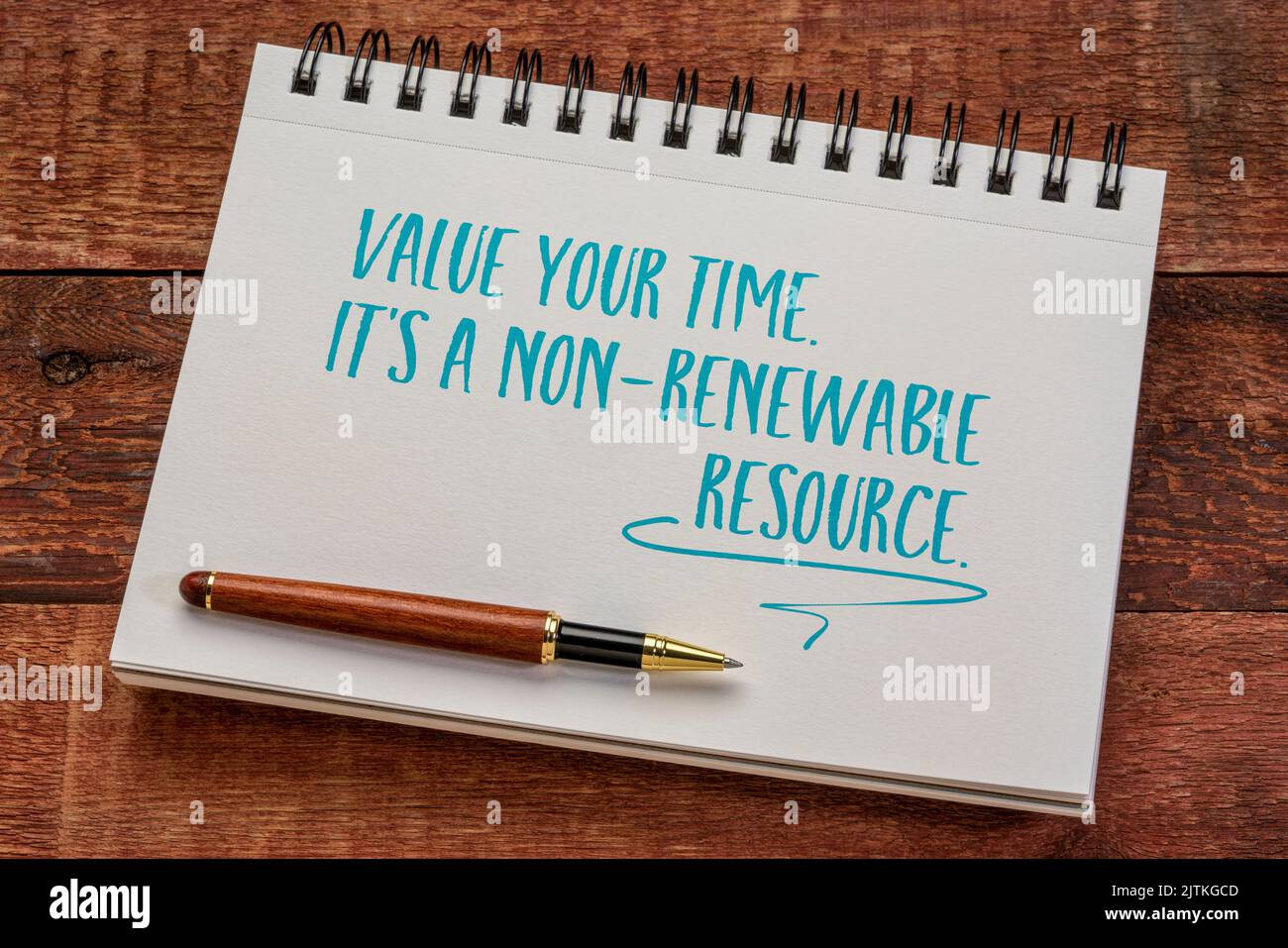 value your time, it's a non-renewable resource, writing in a spiral notebook against rustic wood, productivity and personal development concept Stock Photo
