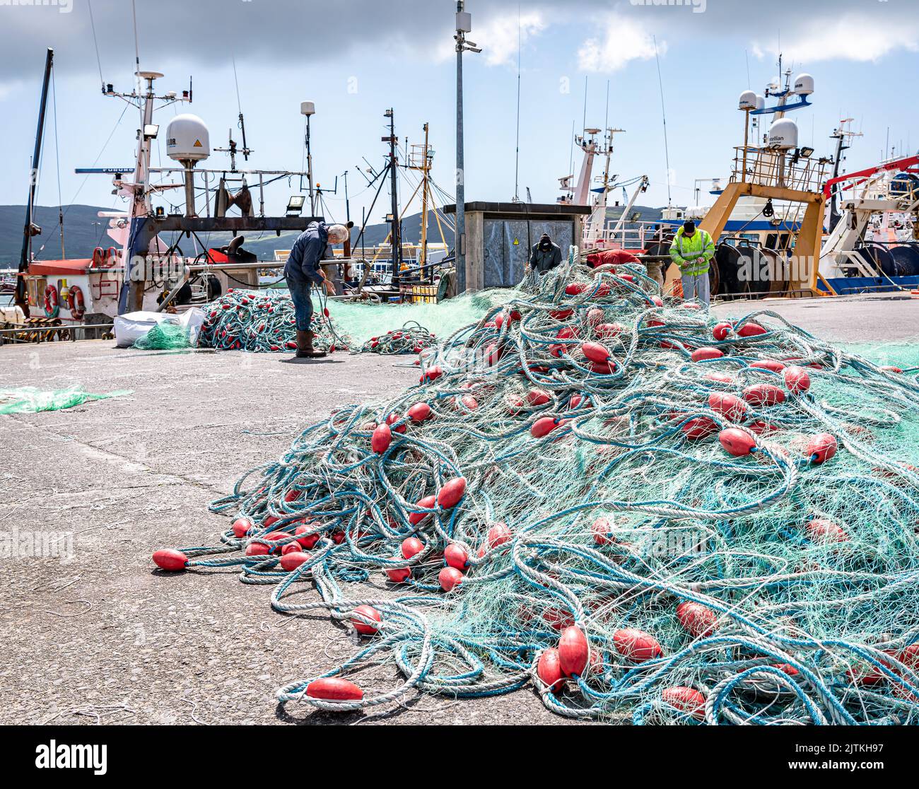 Fishermen  repairing nets  in the Harbour in Castletownbere, County Cork, Ireland Stock Photo