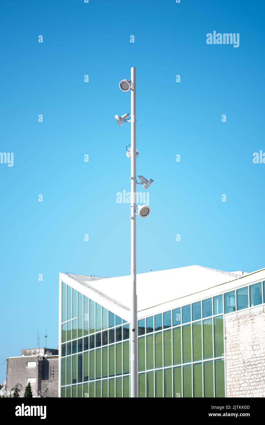 A vertical shot of a street light pole with a building in the background Stock Photo