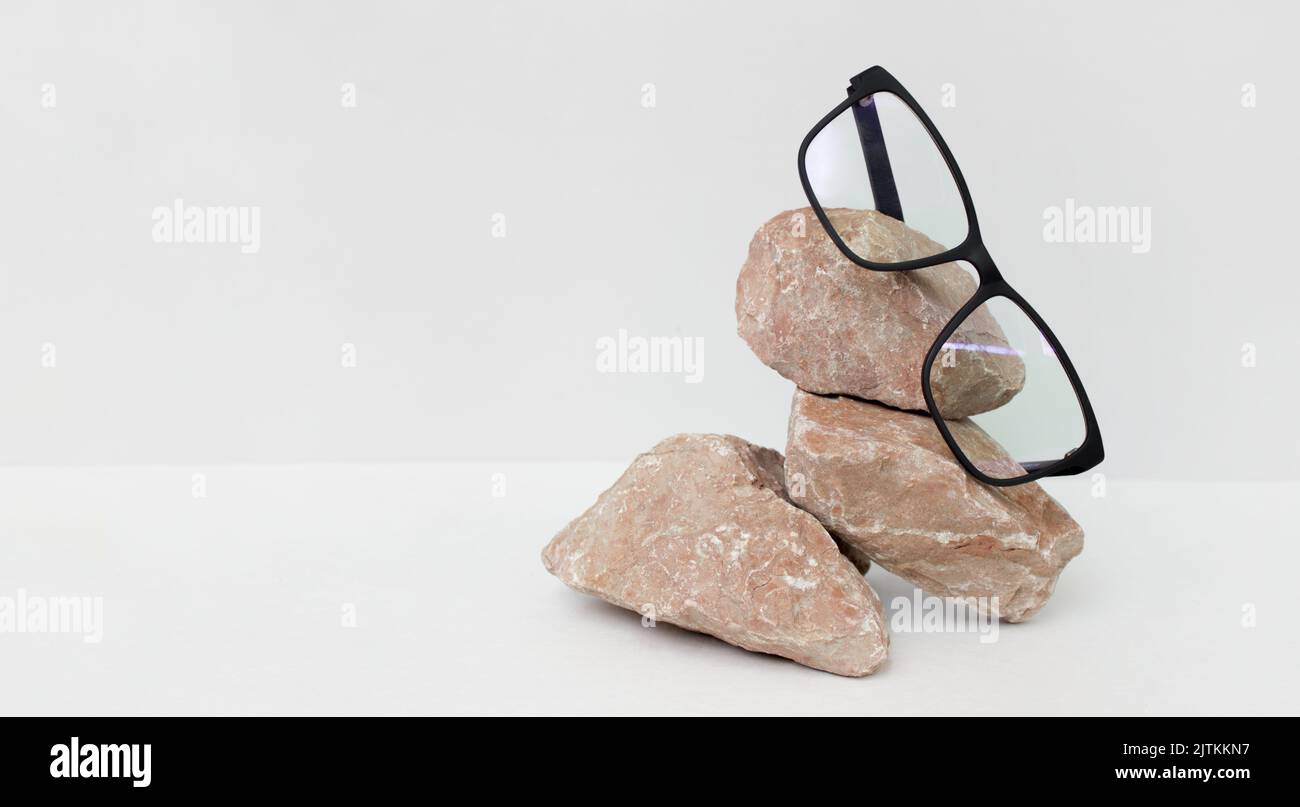 glasses on gray background wjth stone. glasses sale concept. Copy space for text. Optic store discount poster Stock Photo