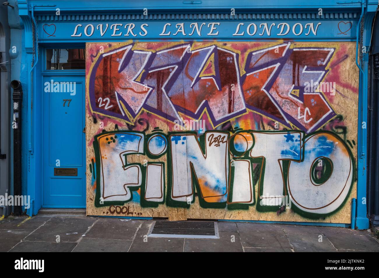 'Lovers Lane' vintage shop in West London, boarded up with graffiti in preparation for the Notting Hill Carnival, 2022. Stock Photo