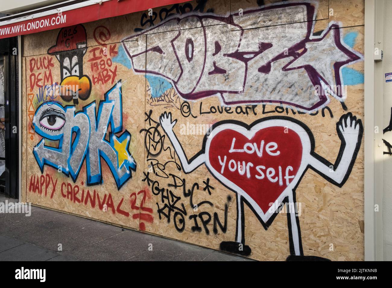 Boarded up shops covered in Graffiti, in preparation for the Notting Hill Carnival in West London, 2022. Stock Photo