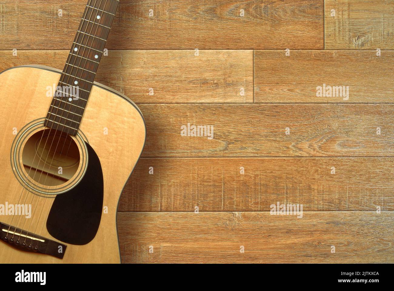 Close up of an acoustic guitar on a wooden floor, shot from above with copy space Stock Photo