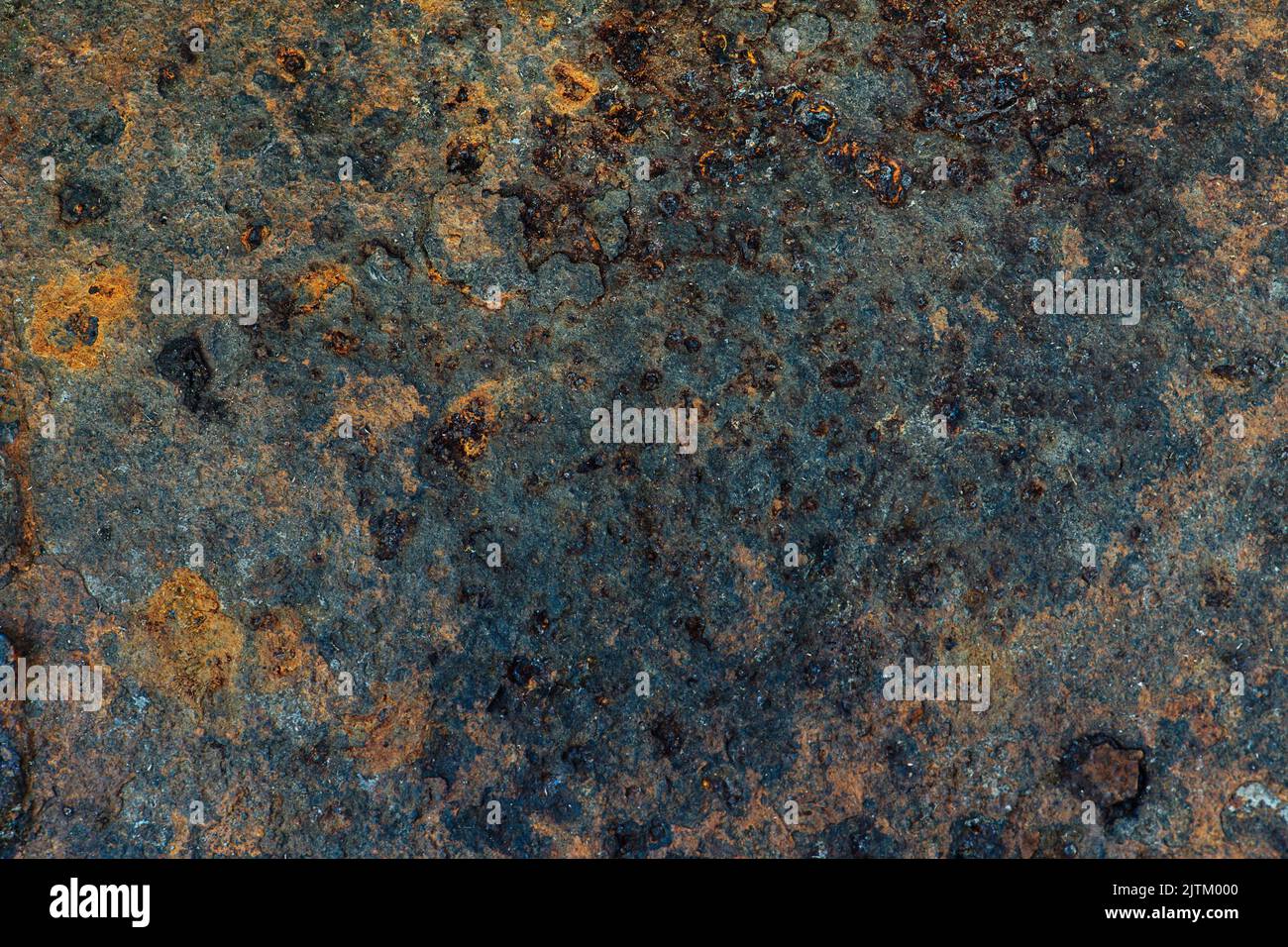 Deformed rusted iron texture with blos and dents. With green and orange
