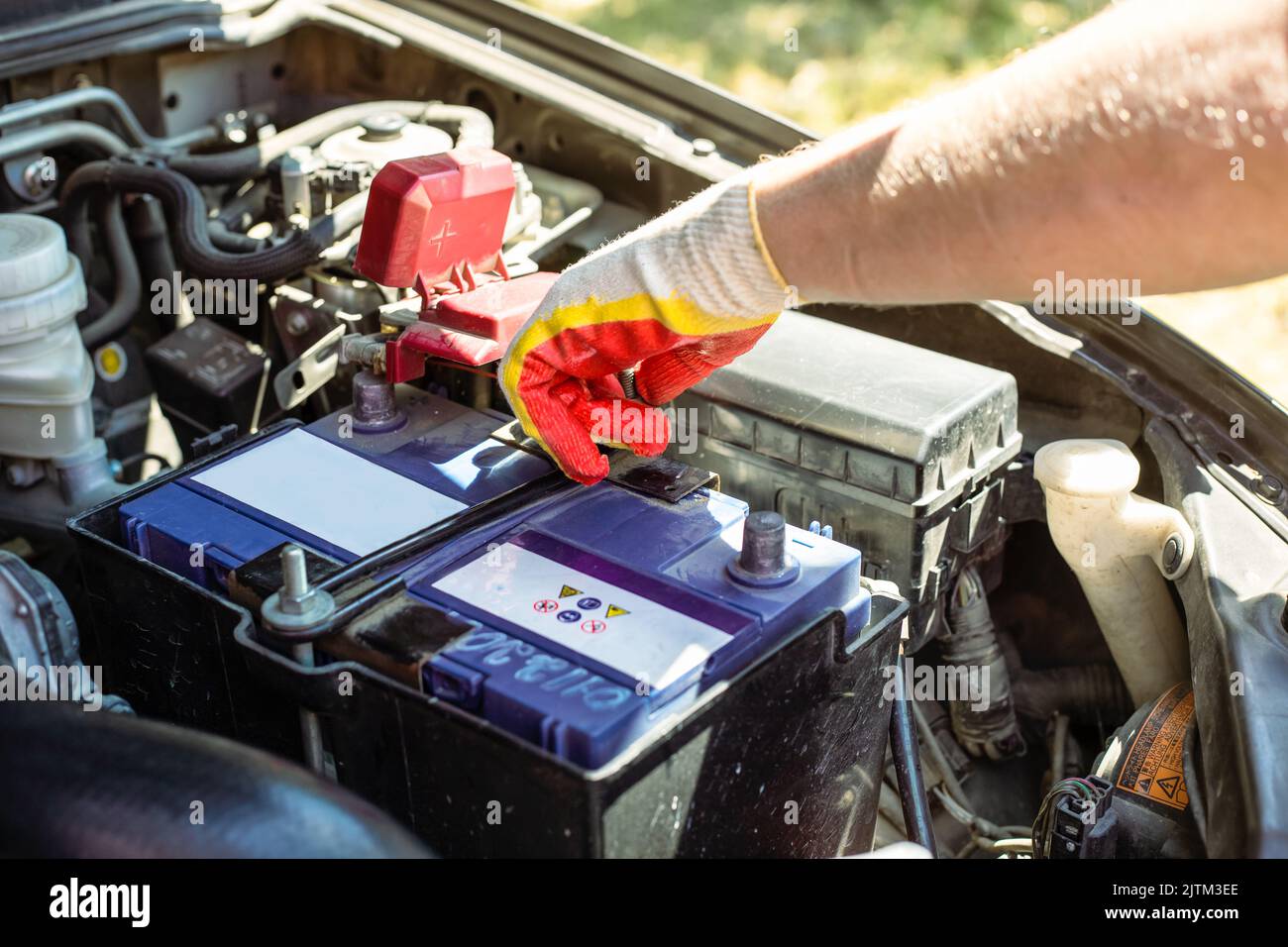 Car battery replacement. The car mechanic repairs the car, unscrews the