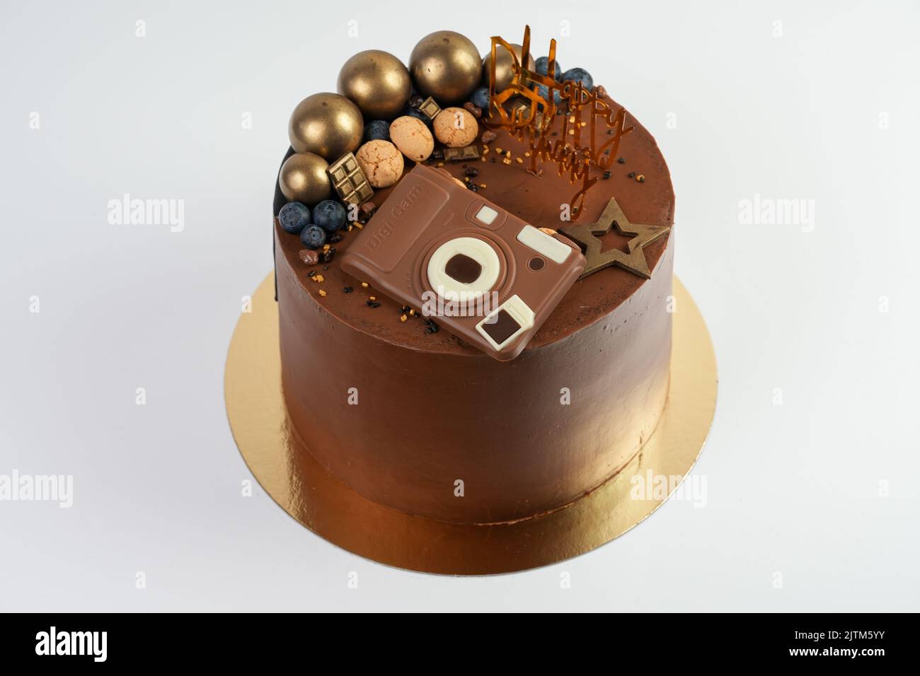 The birthday chocolate cake with golden balls and camera shape ...