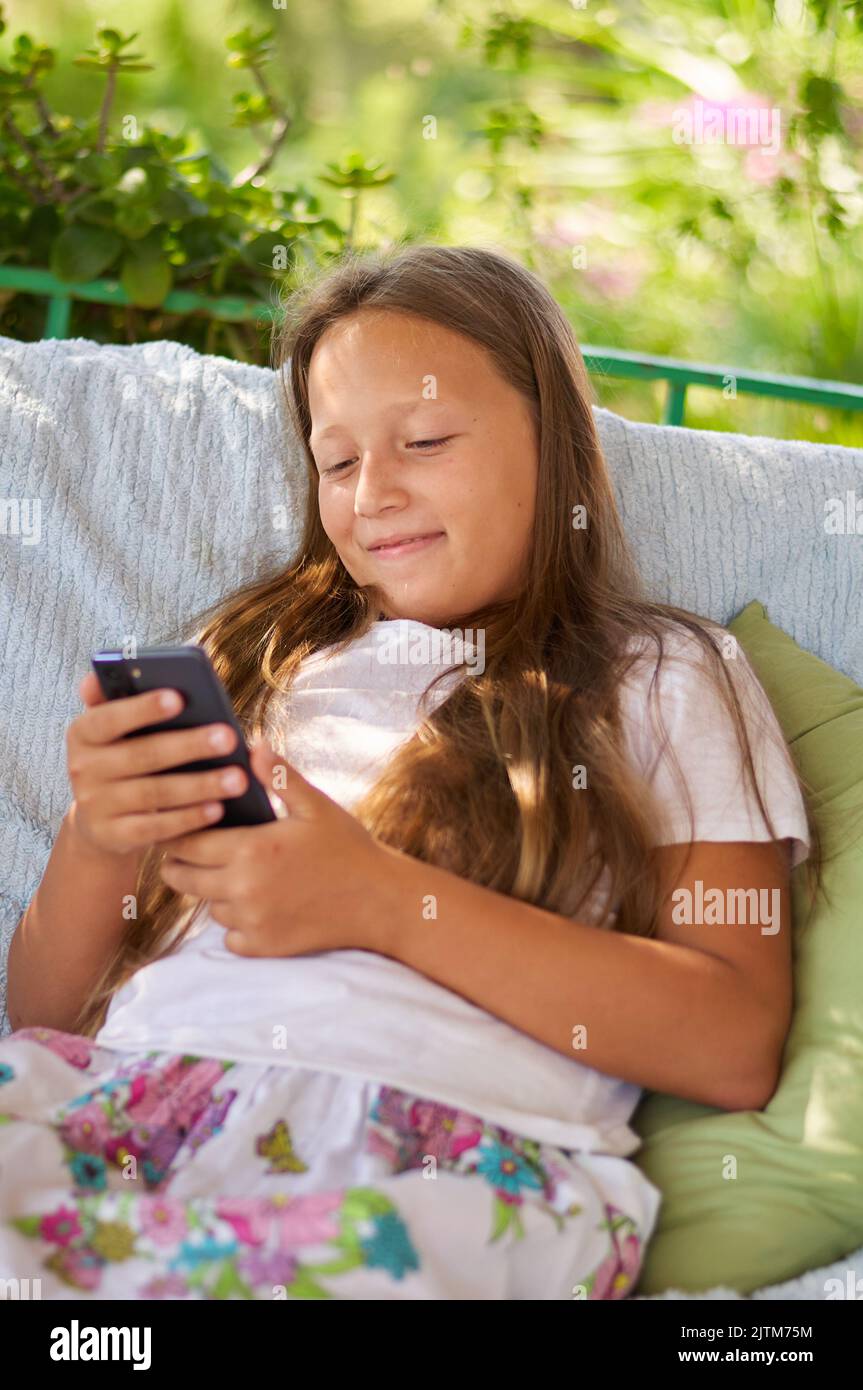 Happy girl sitting on balcony hi-res stock photography and images - Alamy