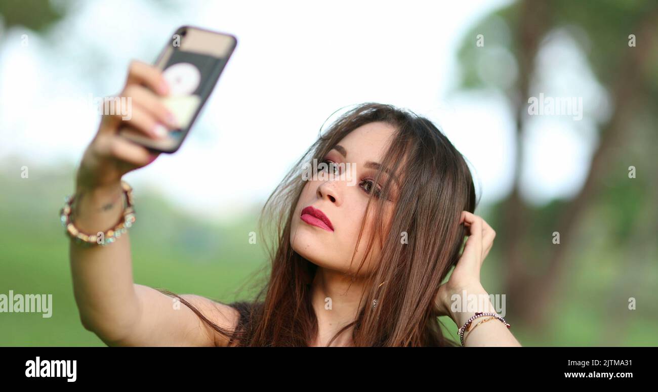 Beautiful young woman taking selfie of herself with phone. Pretty girl ...