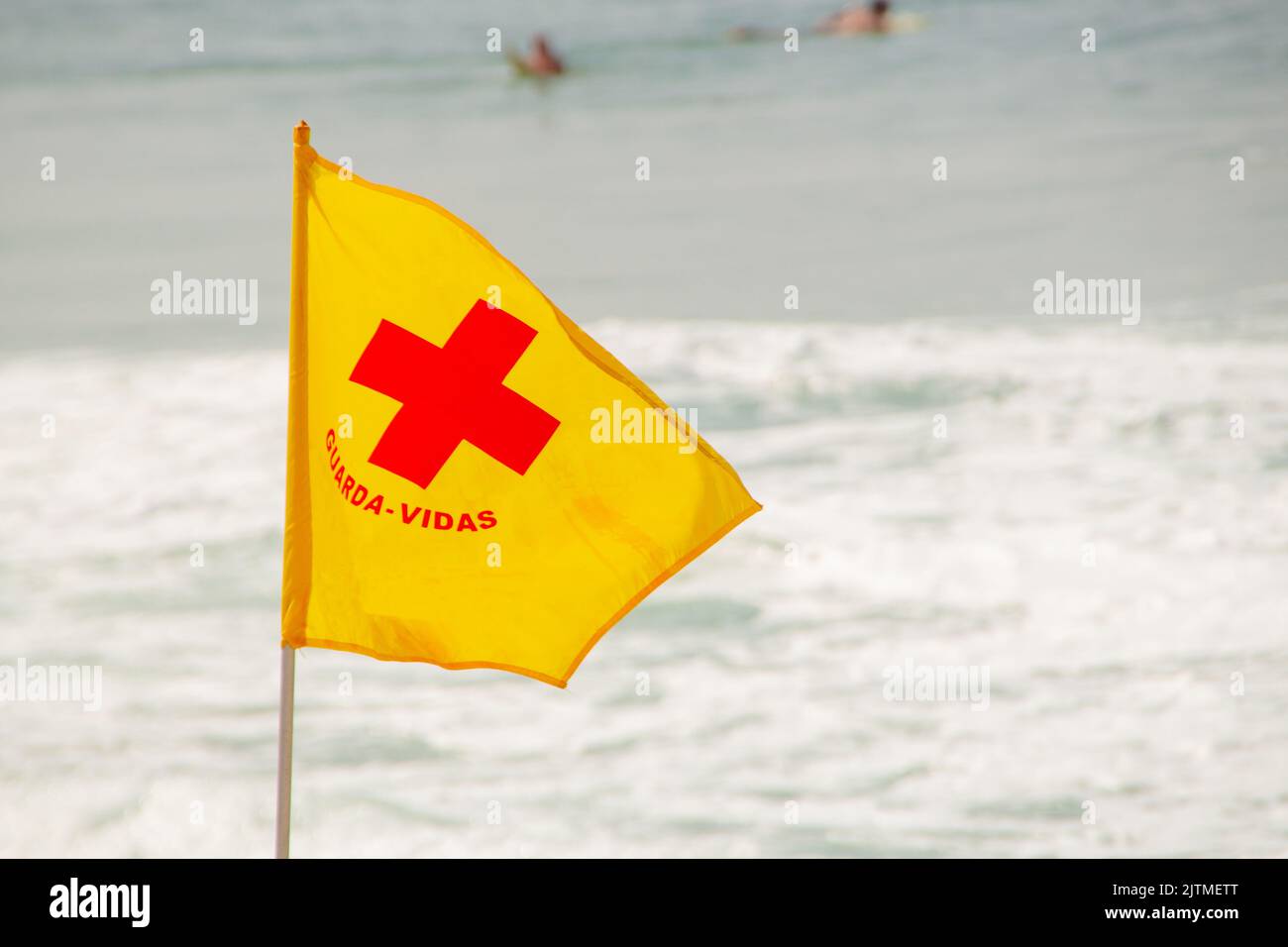 yellow flag with red cross of Lifeguard on a beach in rio de janeiro