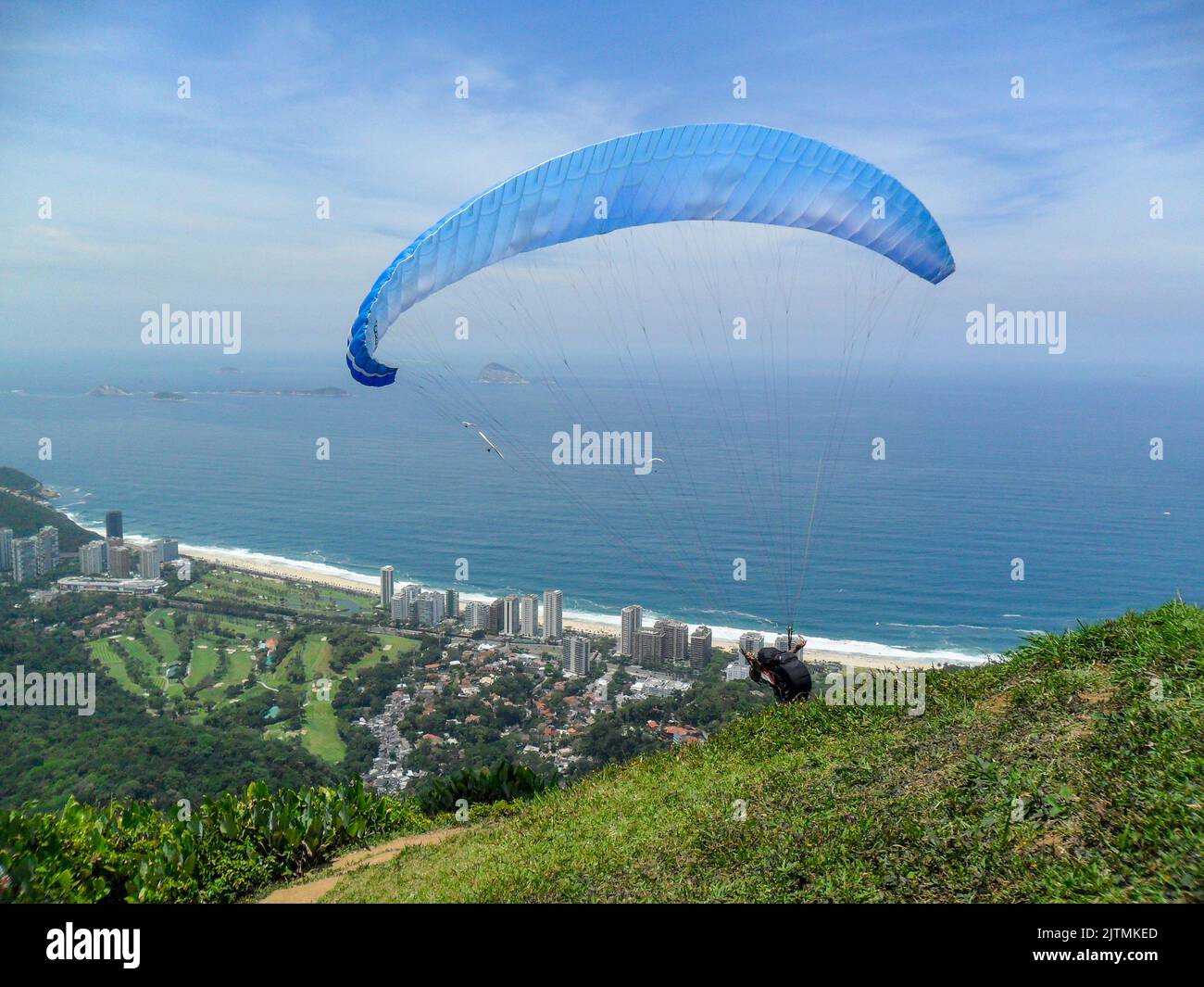 man paragliding on the flight path of the beautiful rock in Rio de Janeiro, Brazil. Stock Photo