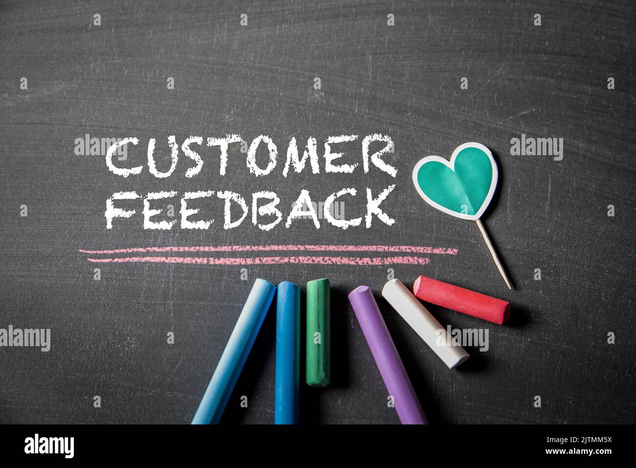 Customer Feedback. Colored pieces of chalk and text on the blackboard. Stock Photo