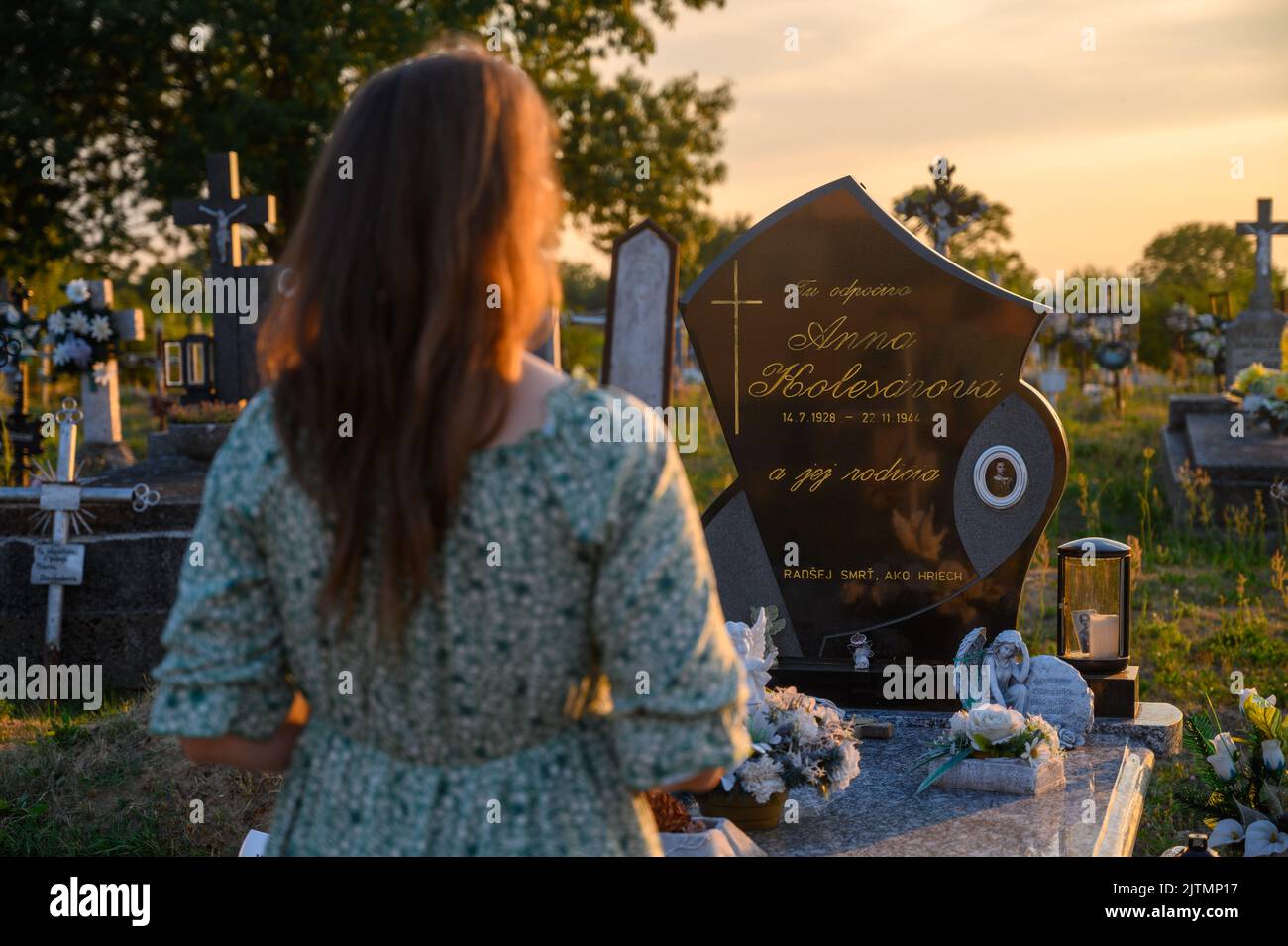 A young woman praying at the grave of blessed Anna Kolesárová, a martyr of chastity. Vysoká nad Uhom, Slovakia. Stock Photo