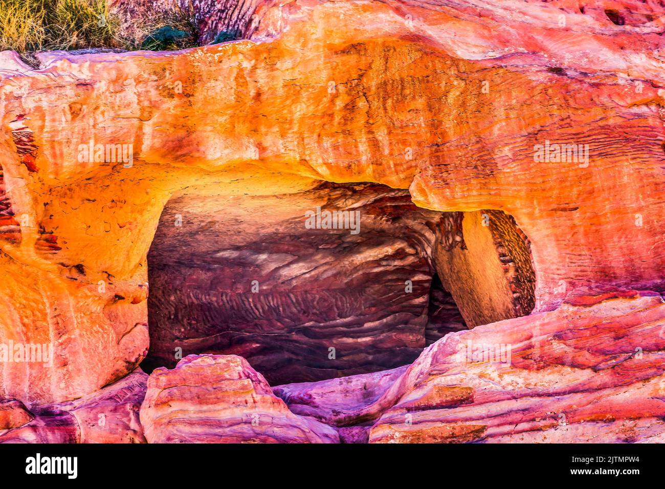Rose Red Yellow Rock Tomb Street of Facades Petra Jordan Built by Nabataens in 200 BC to 400 AD Canyon walls create many colorful abstracts close up Stock Photo