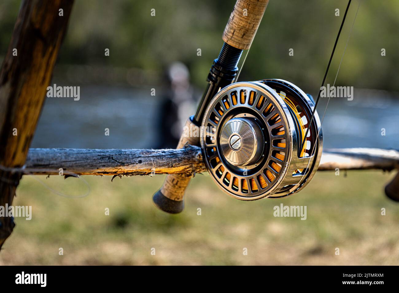 A closeup of a fishing rod on an old wooden stand in sunlight
