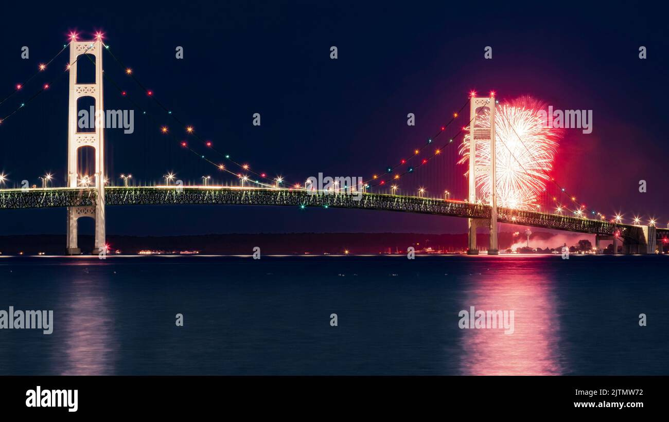 Mackinac Bridge with fireworks from Mackinac City at night as seen from