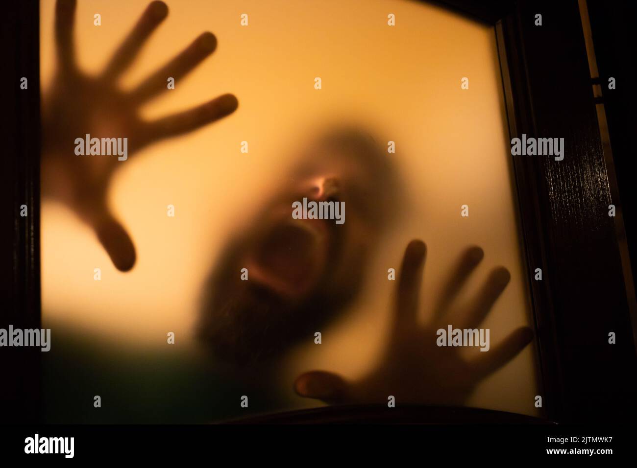 scary picture of hands behind glass, horror ghost behind door, Halloween concept Stock Photo