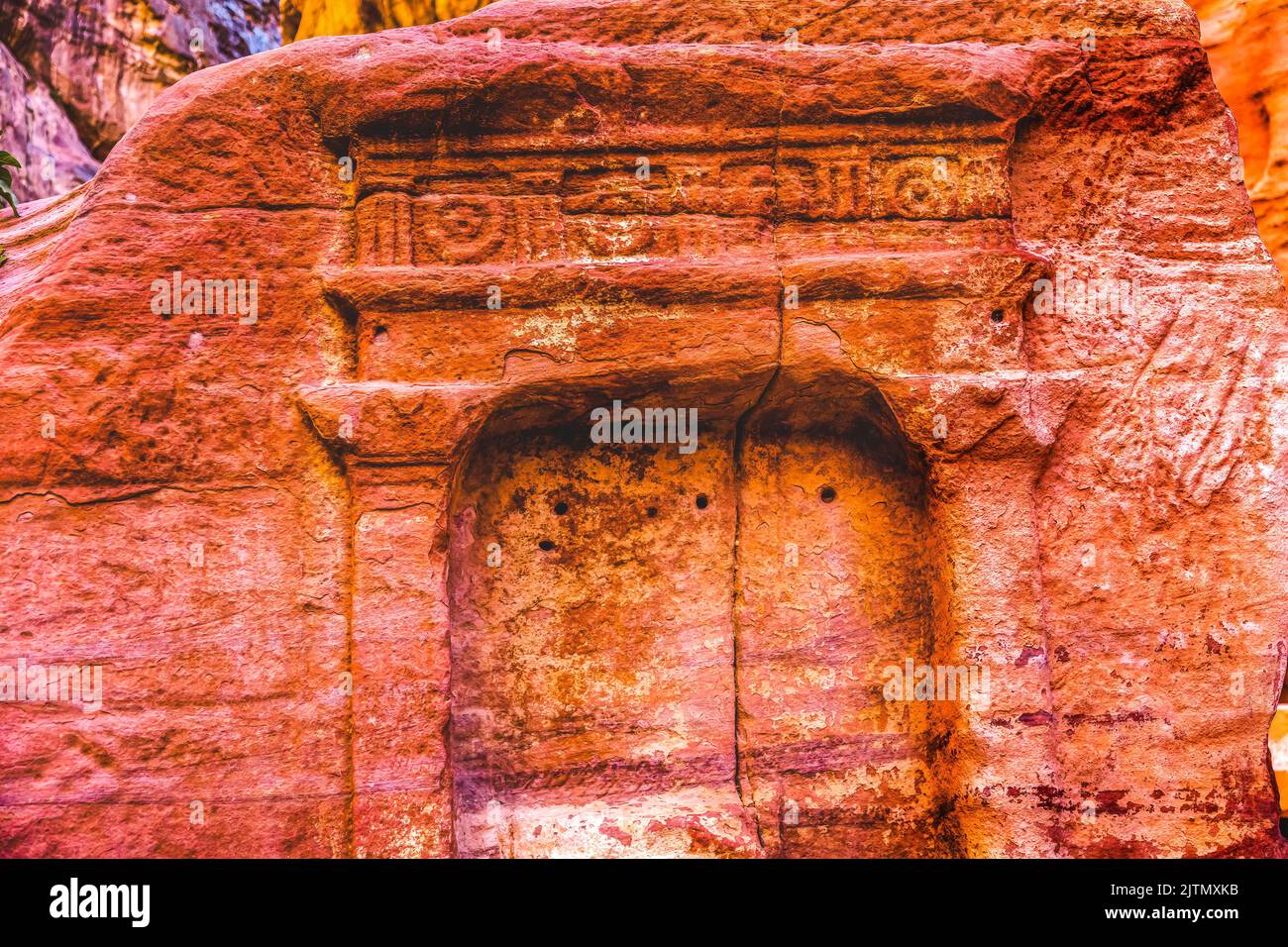 Tomb Outer Siq Canyon Petra Jordan Petra Jordan.  Colorful Yellow Pink Canyon becomes rose red when sun goes.  The rose red can become blood red.  Red Stock Photo