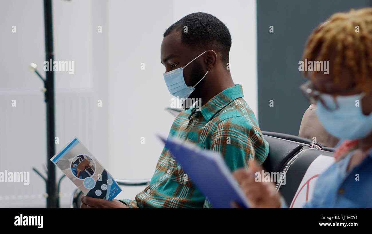 Multiethnic group of patients with face masks in hospital reception