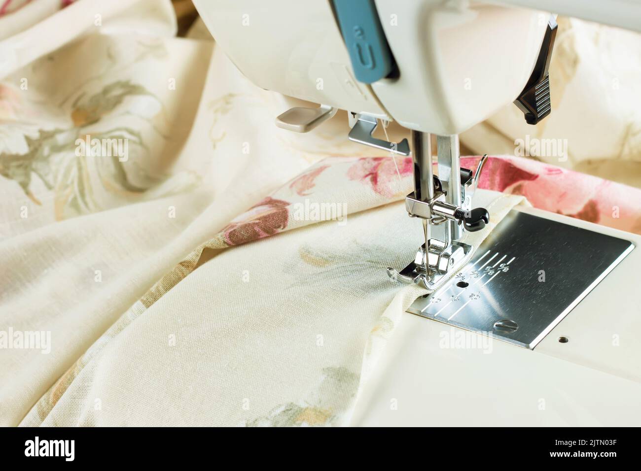 Modern sewing machine presser foot and colofrul cloth. Sewing process