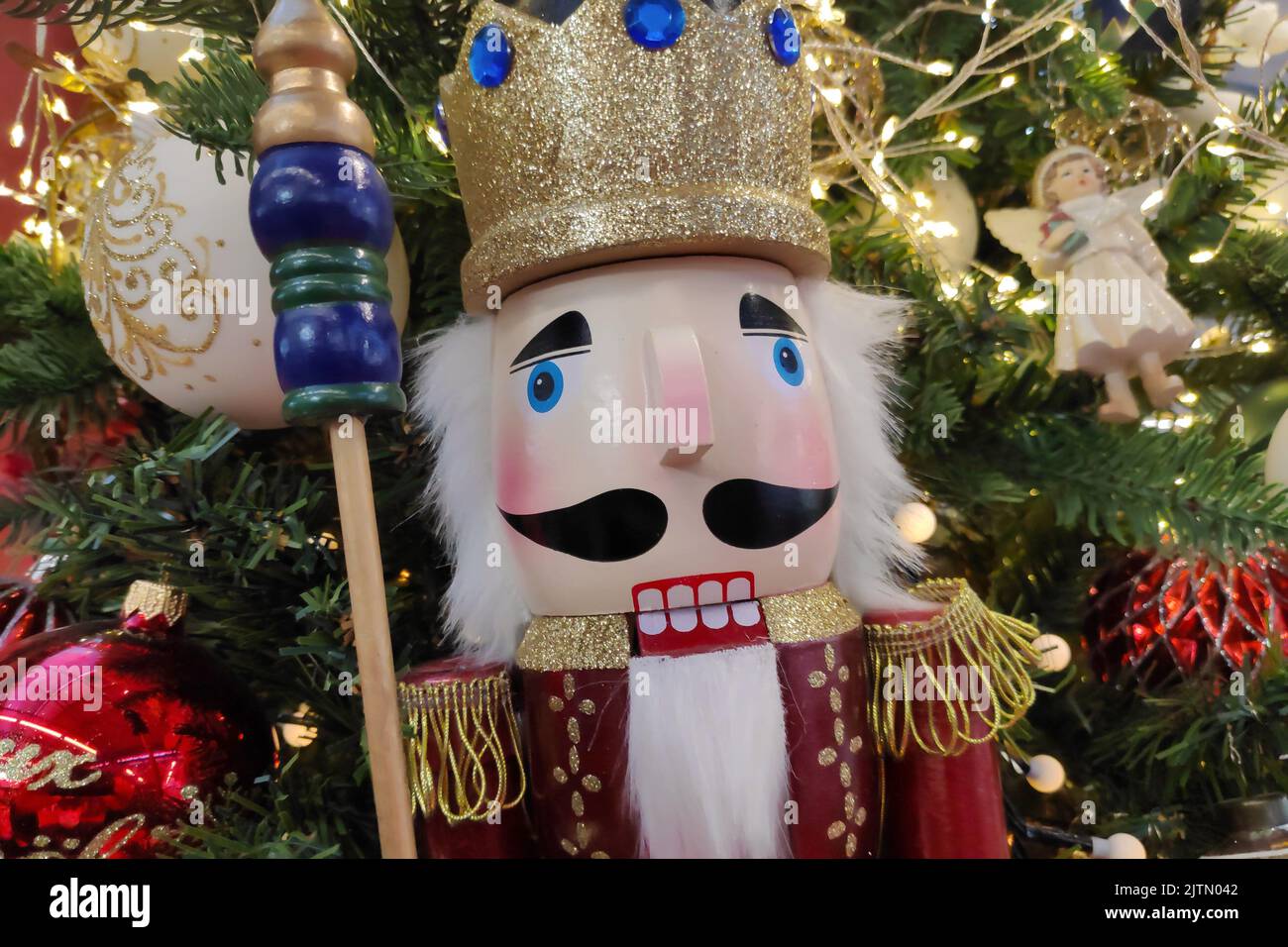 Wooden Nutcracker inside a decorated christmas tree. Stock Photo
