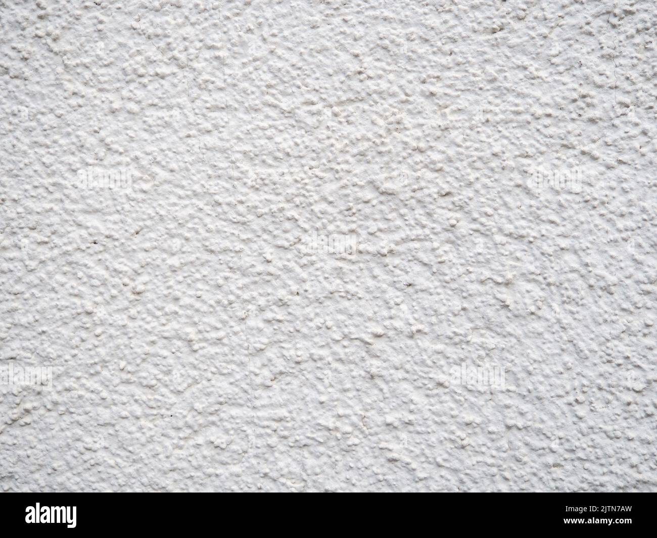 Background from solid material. Pimply white wall. Uneven wall surface