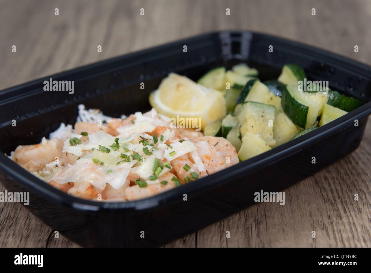 Overhead view of take out order of shrimp with Jasmin rice and chopped vegetables is conveniently packed in a microwavable container. Stock Photo