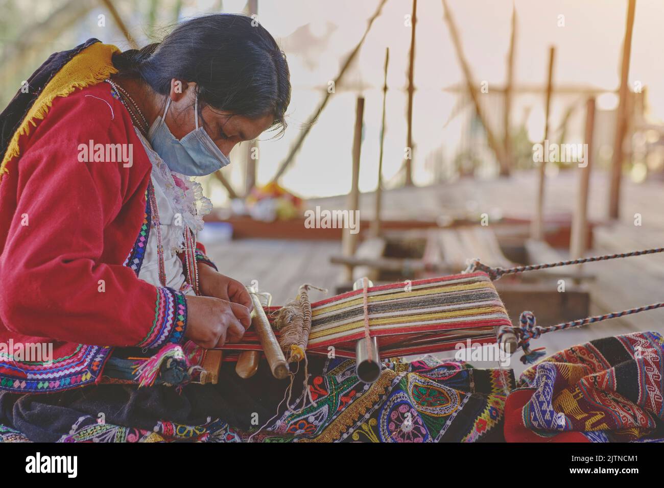 Indigenous woman showing traditional weaving technique and textile