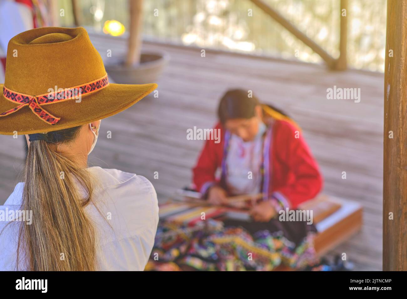 Indigenous woman showing traditional weaving technique and textile making in the Andes mountain