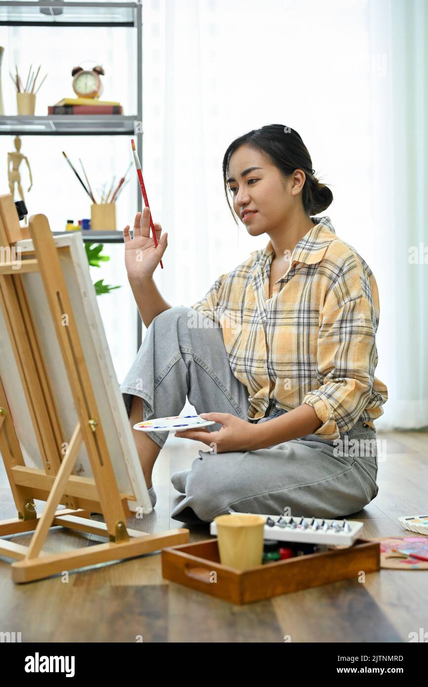 Portrait, A beautiful Asian female painter in the workshop, practicing ...