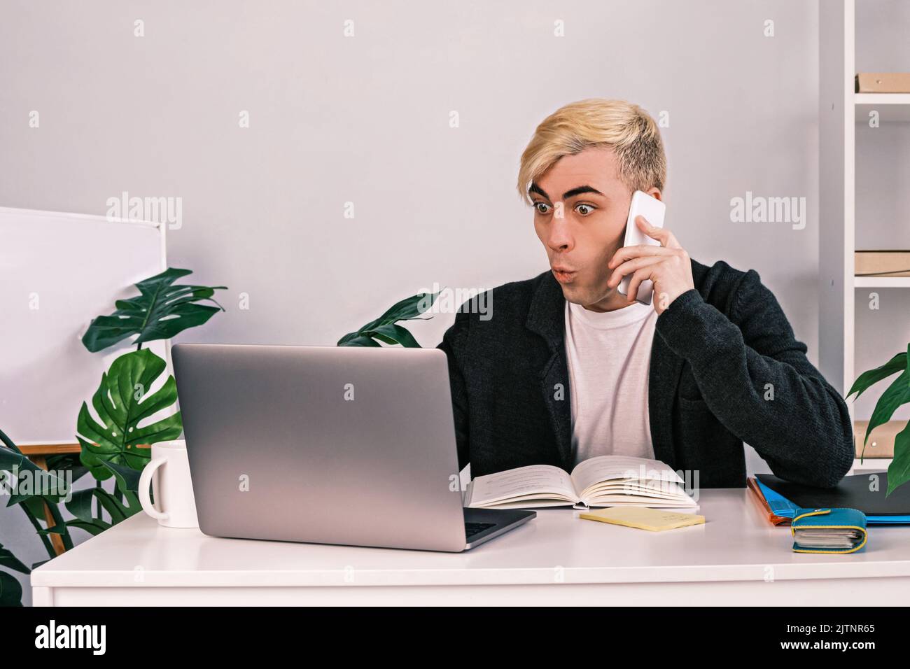 A Young Office Worker Is Shocked And Surprised Looking At A Laptop A Young Office Worker Is Shocked And Surprised Looking At A Laptop
