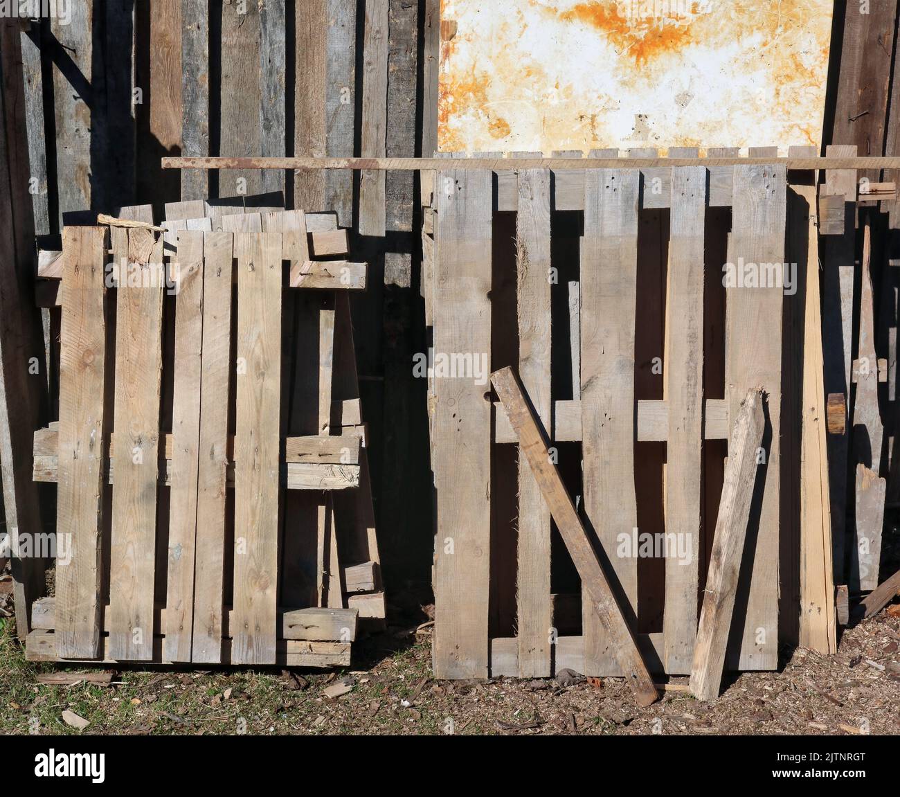 Old used wooden pallets near a rustic  barn Stock Photo