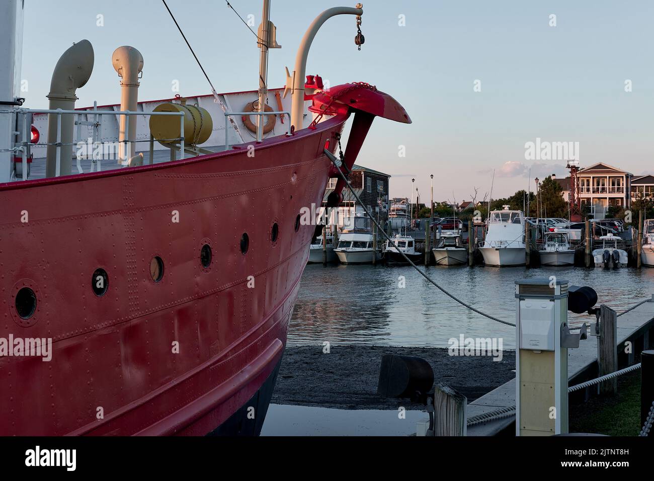 The distinctive red hull of Lightship Overfalls points toward the marina  at Lewes, Delaware. Stock Photo