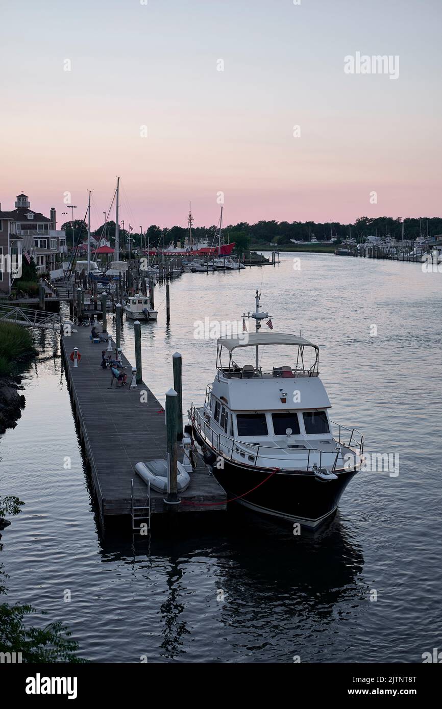 Sunset view of a motor yacht docked at a pier in the Lewes, Delaware marina. Stock Photo