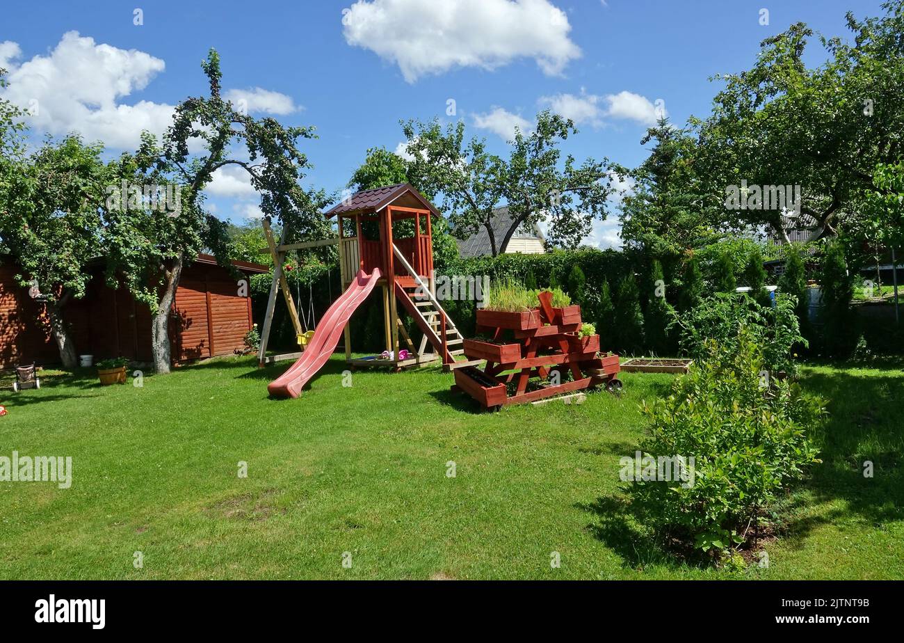 Children's  playgroundin  in summer village garden Stock Photo