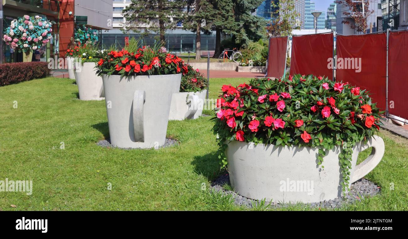 Large concrete vases with fresh flowers near the city shopping  center Stock Photo