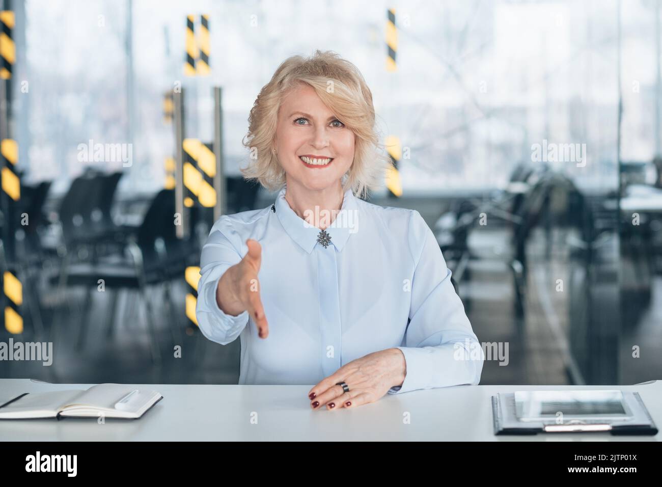 friendly senior lady welcoming successful company Stock Photo