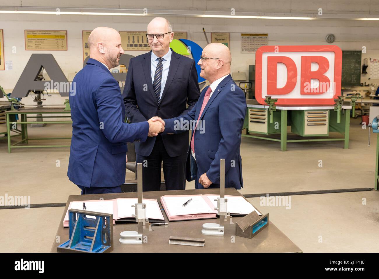 Peitz, Germany. 31st Aug, 2022. Dietmar Woidke (M), Minister President of the State of Brandenburg, watches the signing of the training pact between Deutsche Bahn and LEAG by their HR directors Martin Seiler (L) and Jörg Waniek (R). Deutsche Bahn will take over the apprenticeship workshop of the Lusatian energy company LEAG at the Jänschwalde power plant in the Spree-Neisse district from 2025 onwards Credit: Frank Hammerschmidt/dpa/Alamy Live News Stock Photo