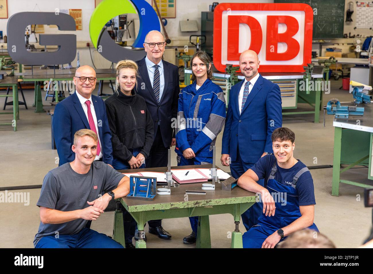 31 August 2022, Brandenburg, Peitz: Marcel Leutert (l-r) LEAG apprentice, Martin Seiler, Deutsche Bahn Board Member for Human Resources, Martha Schröder, LEAG apprentice, Dietmar Woidke, Minister President of the State of Brandenburg, Denise Gölitzer, LEAG apprentice, Jörg Waniek, LEAG Board Member for Human Resources and LEAG apprentice Lucian Roschek stand in front of the camera for a photo with LEAG apprentices after the signing ceremony. Deutsche Bahn will take over the apprentice workshop of the Lusatian energy company LEAG at the Jänschwalde power plant in the Spree-Neisse district from Stock Photo