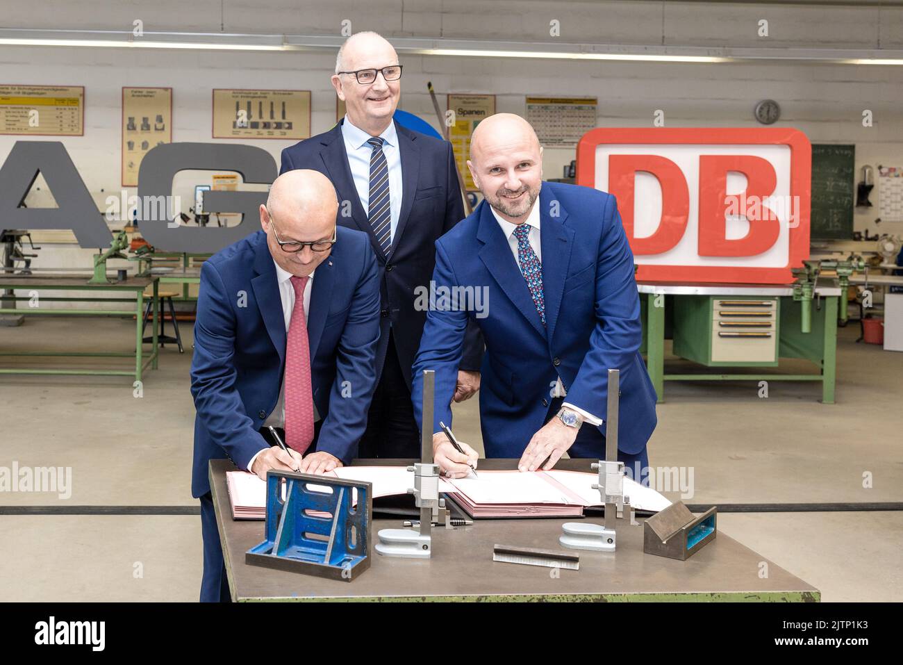 Peitz, Germany. 31st Aug, 2022. Dietmar Woidke (M), Minister President of the State of Brandenburg, watches the signing of the training pact between Deutsche Bahn and LEAG by their HR directors Martin Seiler (L) and Jörg Waniek (R). Deutsche Bahn will take over the training workshop of the Lusatian energy company LEAG at the Jänschwalde power plant in the Spree-Neisse district from 2025 onwards Credit: Frank Hammerschmidt/dpa/Alamy Live News Stock Photo